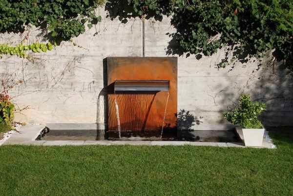 Wasserfall stehend am Gartenteich als Wasserzulauf mit breitem Wasserschwall