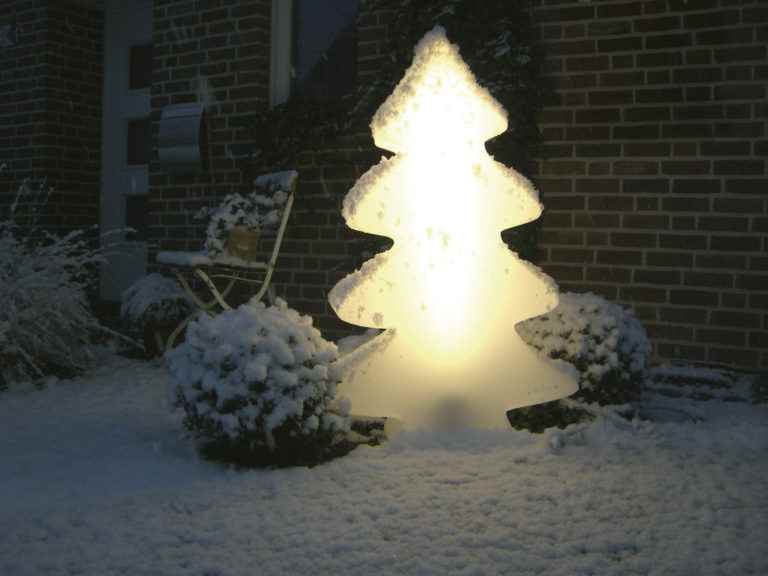 Leuchtender Weihnachtsbaum verschönert Haus und Garten