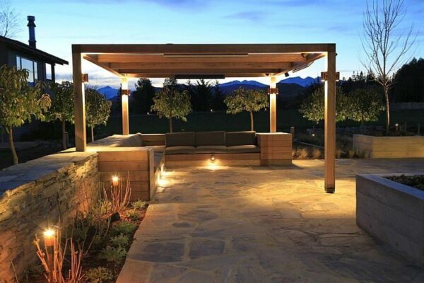 Kleine Wandaufbauleuchte aus Bronze perfekt auf eine Natursteinwand für eine Terrasse